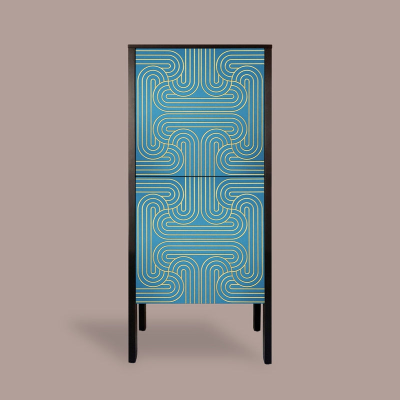 A modern two-door cabinet featuring a vibrant blue and teal geometric pattern on the doors, framed in black with slim black legs, set against a solid taupe background.