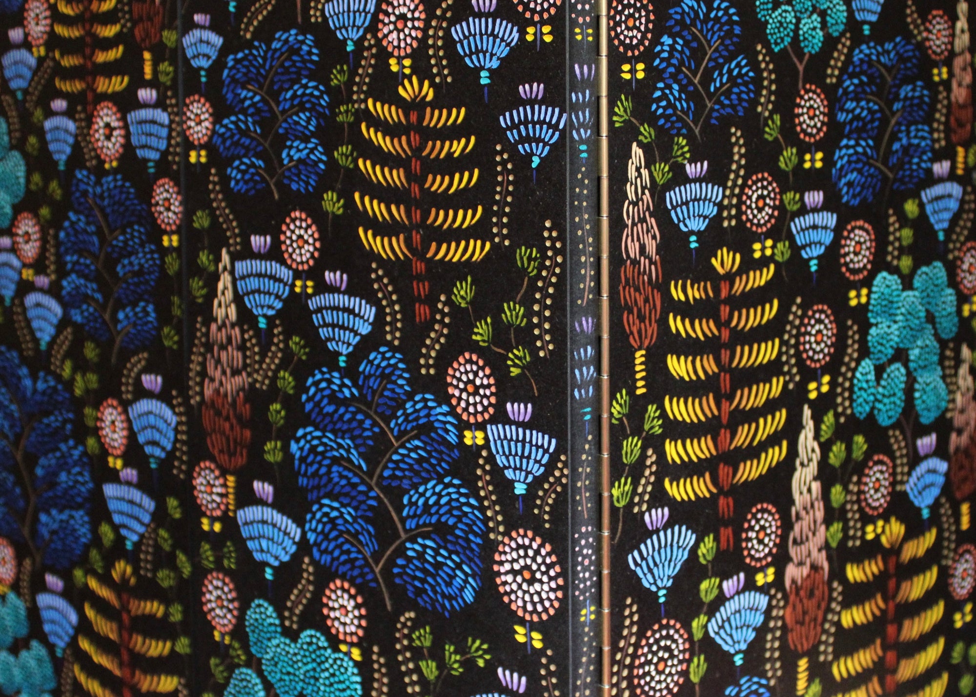 Close-up of a carved and painted floral pattern on doors of furniture