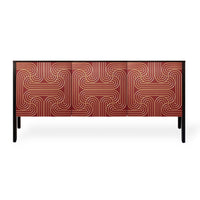 A modern sideboard or credenza with geometric patterned doors in red with a carved pattern painted in gold. Supported by slim black legs, shown against a plain white background.