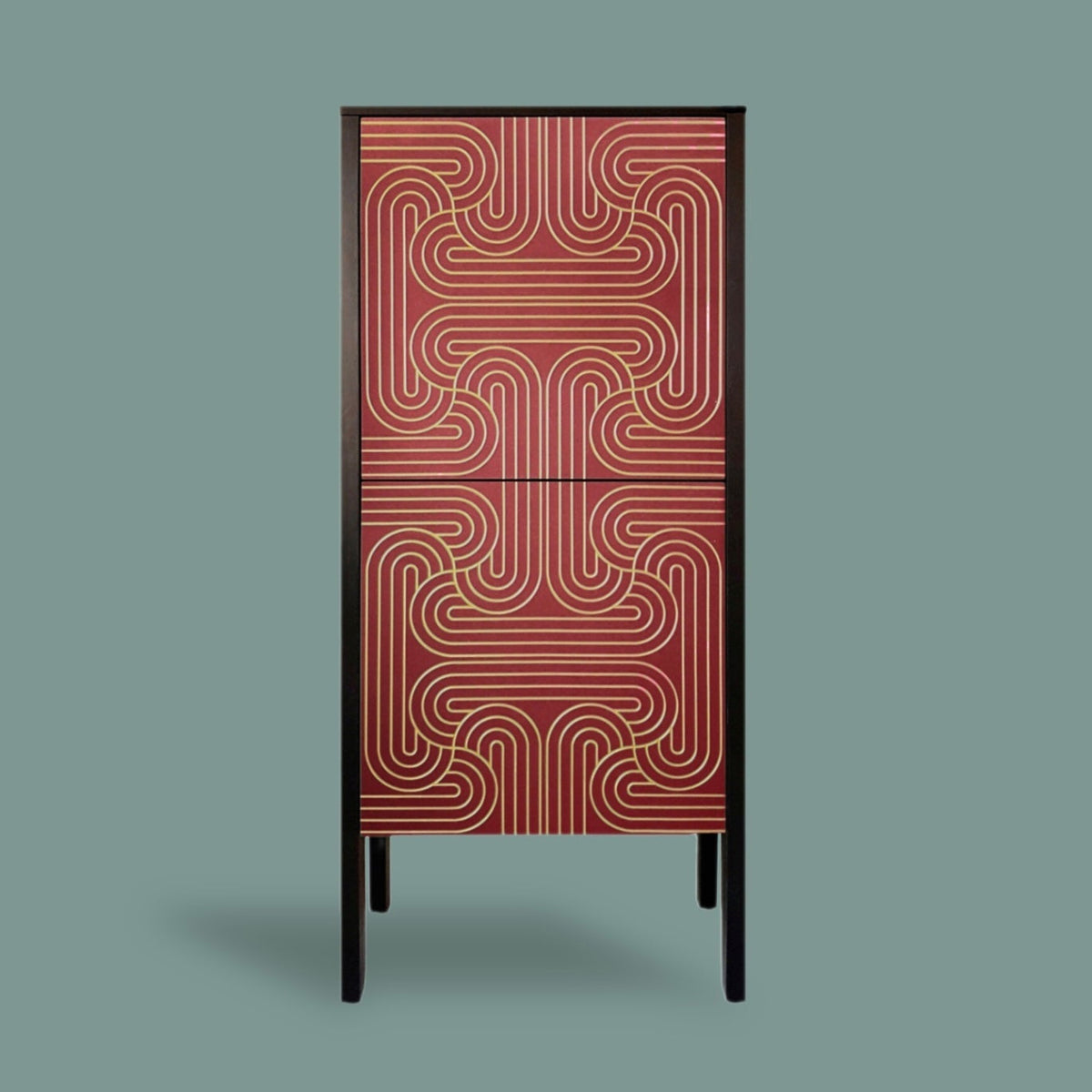 A tall, narrow cabinet with two doors featuring a red and gold wavy geometric pattern, supported by slim black legs, set against a solid muted green-gray background.